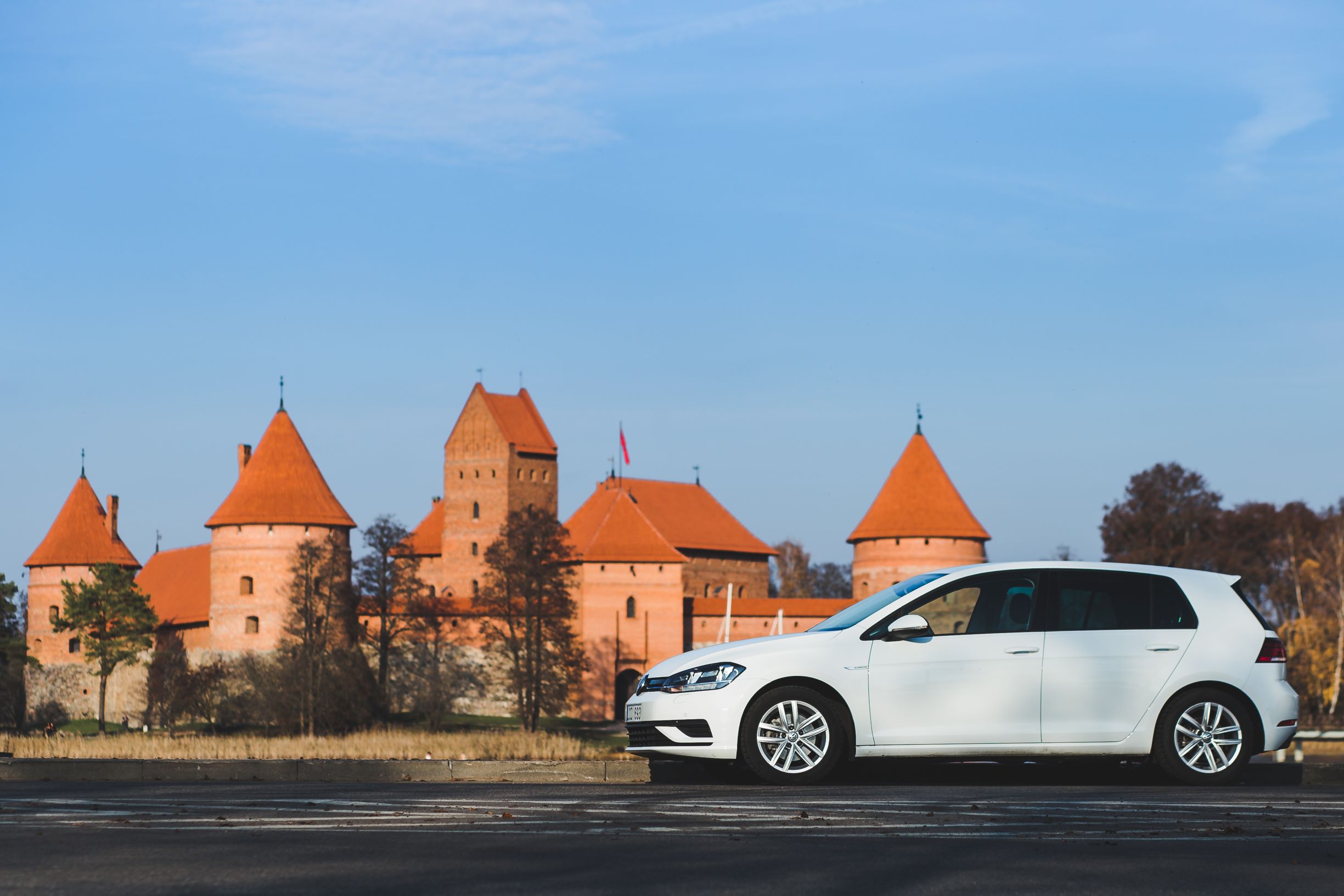 A car from Autocom Car Rental in front of Trakai castle